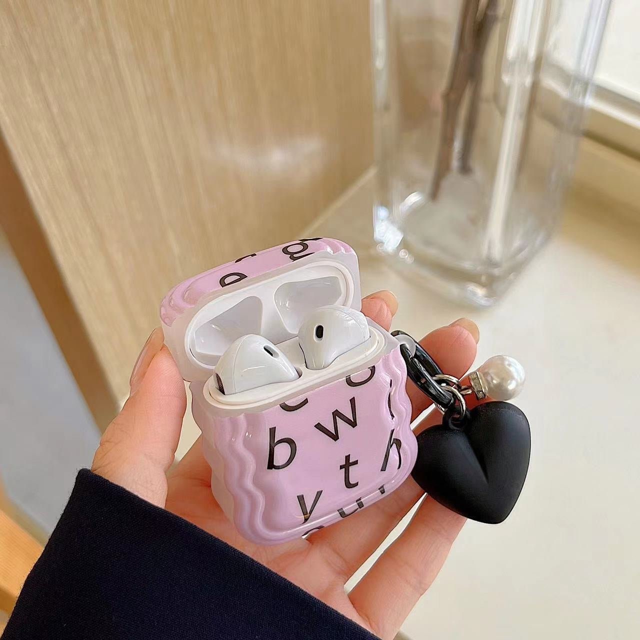 Fialový kryt na AirPods s abecedou